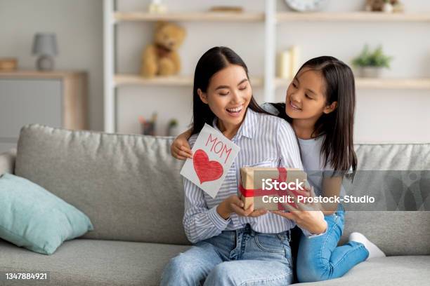 Congratulations Loving Asian Daughter Greeting Surprised Mom With Mothers Day Giving Her Handmade Card And Gift Box Stock Photo - Download Image Now