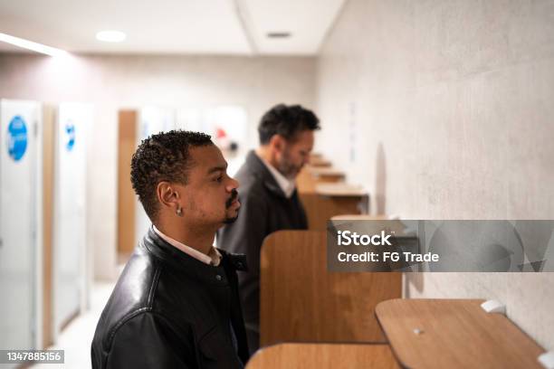 Two Men Urinating At A Public Restroom Stock Photo - Download Image Now - Urinal, Urinating, Only Men