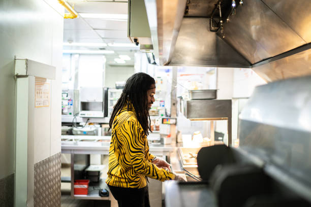 Mid adult man cooking at a fast food kitchen