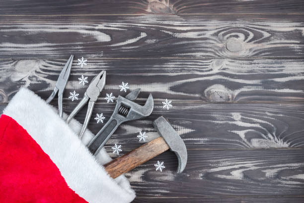 istock Flat composition with construction tools in santa claus hat on wooden background. The concept of New Year and Christmas in the construction industry. Top view. Flatly. Copy space 1347886959
