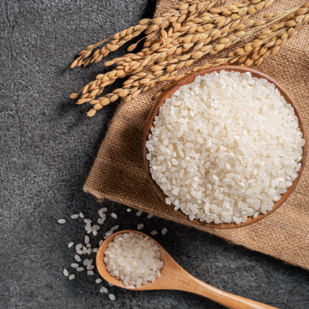 istock White rice in a bowl on dark black table background. 1347889848
