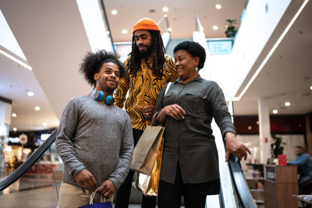 mutter und sohn reden und spazieren im einkaufszentrum - family african ethnicity black african descent stock-fotos und bilder