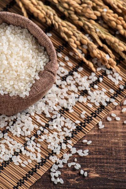 istock Raw white rice in a wooden bowl over table. 1347890178