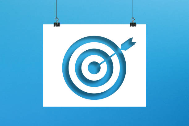 istock Target sign on paper hanging with clip on blue background 1347890181