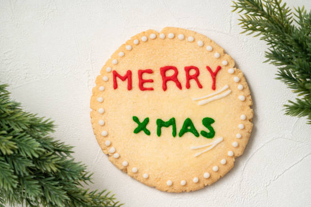 Decorated Christmas gingerbread cookies with decorations on white table background.