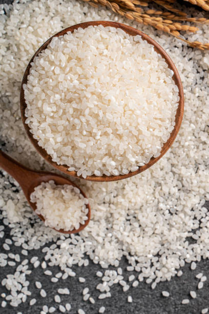 istock White rice in a bowl on dark black table background. 1347890296
