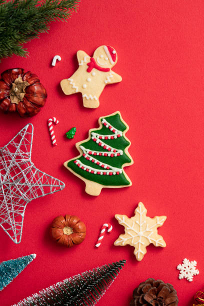 istock Decorated Christmas gingerbread cookies with decorations on red table background. 1347890318