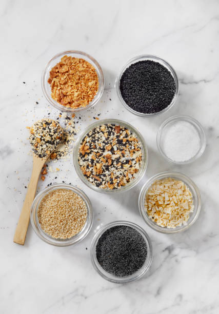 Making Everything Bagel Seasoning Making Everything Bagel Seasoning: Poppy Seeds, Dehydrated Onion Flakes, Dehydrated Garlic, Toasted Sesame Seeds, Black Sesame Seeds and Sea Salt salt seasoning stock pictures, royalty-free photos & images