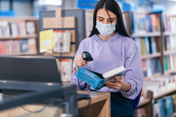 istock University student scanning a book in  library 1347891517