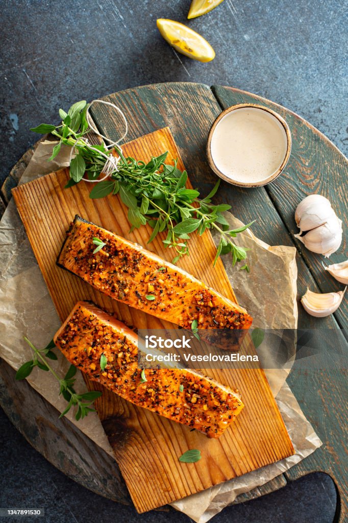 Cedar plank roasted salmon Cedar plank grilled or roasted salmon with herbs, garlic and spices Salmon - Seafood Stock Photo
