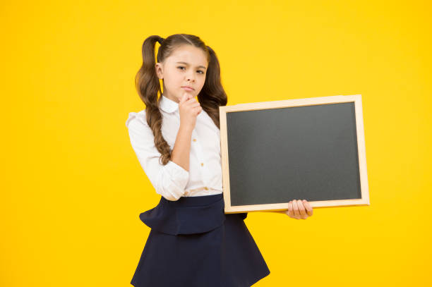 istock Get information on education. Little child holding blank blackboard for education on yellow background. Compulsory primary school education. Advertising education course, copy space 1347893225