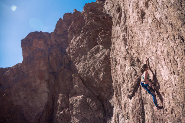 istock Young woman with climbing equipment on a rock wall 1347893435
