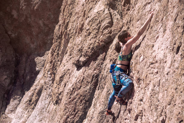 istock Young woman with climbing equipment on a rock wall 1347893462