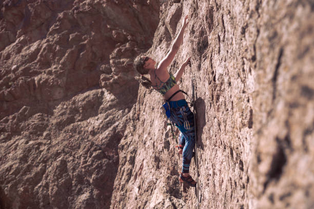 istock Young woman with climbing equipment on a rock wall 1347893463