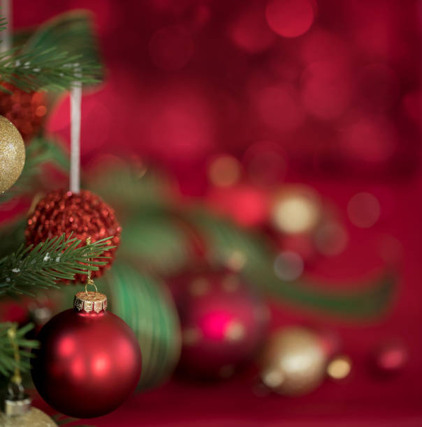 istock Red and Gold Ornaments on a Christmas Tree with a Red Bokeh Background 1347894583