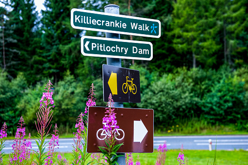 A sign post in Pitlochry, Scotland, just north of Edinburgh.  The sign is directing hikers to the scenic Pitlochry Dam as well as a longer hike along the River Tummel.