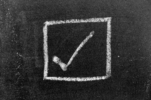 istock White color chalk hand drawing in right checkmark in square box shape on black board background 1347894762