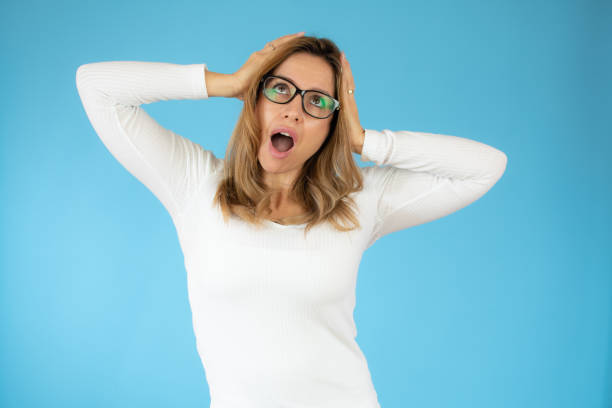 istock Indignant discontent young female points at herself, asks why its her duty, frowns face in displeasure, expresses disagreement, wears white sweater, isolated over blue background. Why me? 1347895979