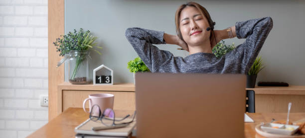 istock Cropped shot smiling asian woman freelancer wearing headset, communicating with client via video computer call. Millennial pleasant professional female tutor giving online language class 1347897105