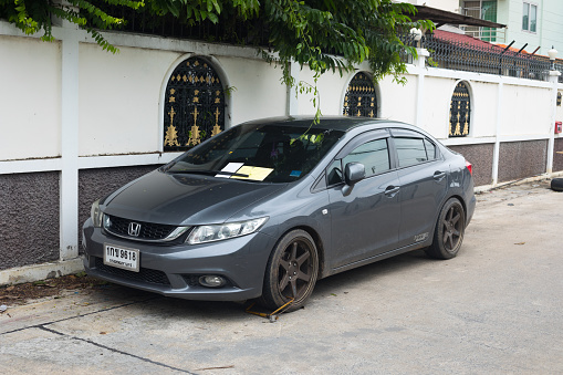 Car with parking ticket and claw at wheel in Bangkok Chatuchak