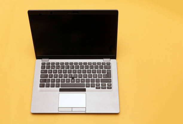 istock Open modern PC laptop on yellow background 1347900684