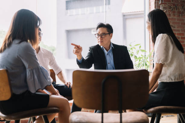 Angry leader pointing out his employee in bright office Disgruntled multiethnic team scolding female colleague who made bad work-related mistake. business criticism stock pictures, royalty-free photos & images