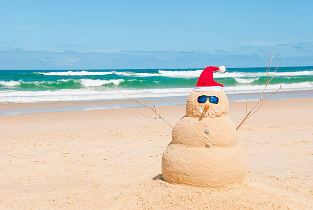 Snowman resists melting process on beach stock photo