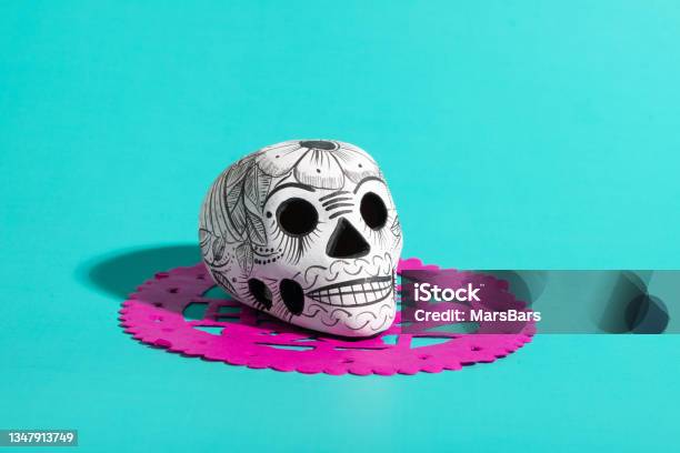 Day Of The Dead Pottery Skull On Hot Pink Papel Picado On Teal Blue Background Dia De Muertos Background Stock Photo - Download Image Now