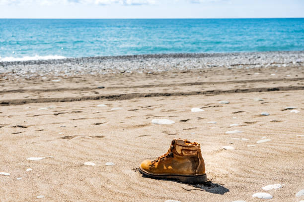 lonely yellow boot on the seashore. washed ashore a boot from a man who drowned