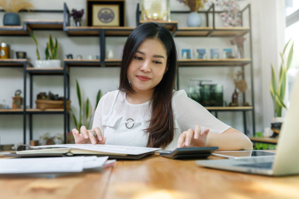 Young asian woman in smart casual wear working in home office. Social distance practice prevent coronavirus COVID-19. stock photo