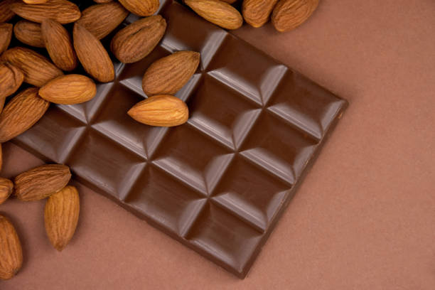 istock Milk chocolate bar with almonds brown frame top view stock images 1347917238