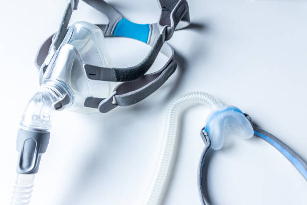 閉塞性睡眠時無呼吸に対するcpapマスクは、患者の呼吸マスクヘッドギアクリップを鼻と喉の呼吸薬に対するcpapマシンとのいびきおよび睡眠障害に対する呼吸を容易にするのに役立ちます - cpap ストックフォトと画像