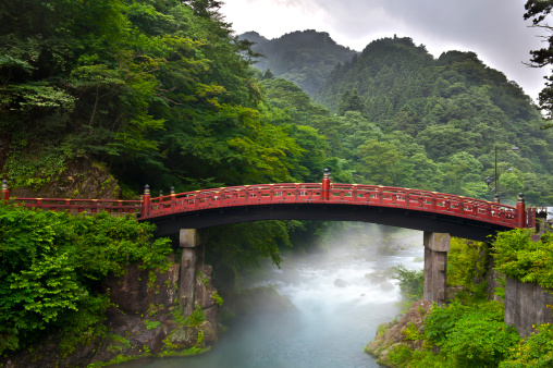 Red sacred bridge Shinkyo in Nikko, Japan and a mist rising from the river
