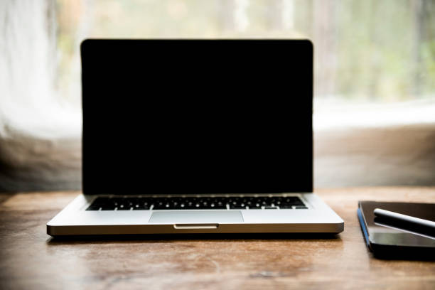 istock Laptop with blank screen on table in office loft 1347923500