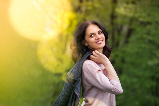 istock Middle-age woman in black leather jacket, holds her jacket over the shoulder. 1347924802