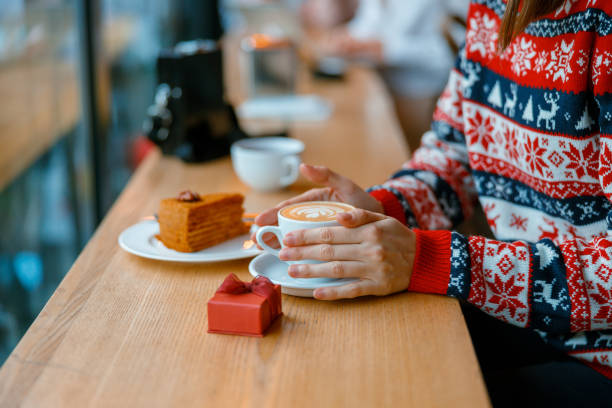 istock hands holding a capuchino cup with gift box and cake on a cozy cafe terace 1347925329