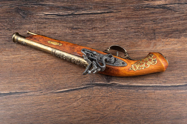 istock A replica of an old muzzle-loaded pistol on a wooden background. 1347927675