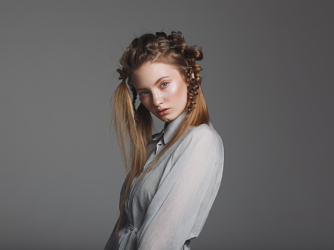 Portrait of young beautiful woman with braids