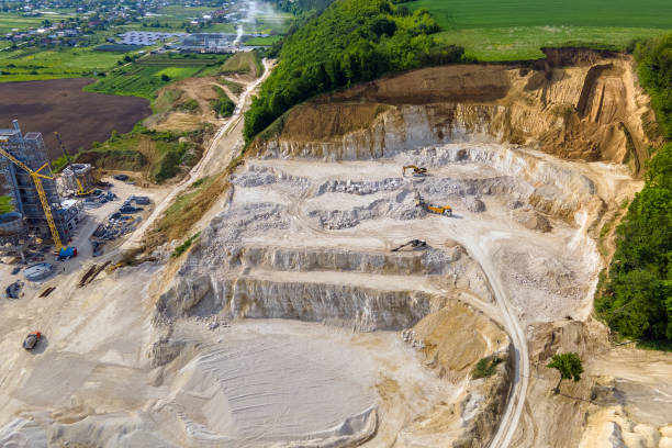 istock Open pit mining of construction sand stone materials with excavators and dump trucks. 1347928924