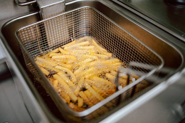 Close-up of fries in deep fryer. Restaurant meal preparation, side dish Close-up of fries in deep fryer. Restaurant meal preparation, side dish deep fryer stock pictures, royalty-free photos & images