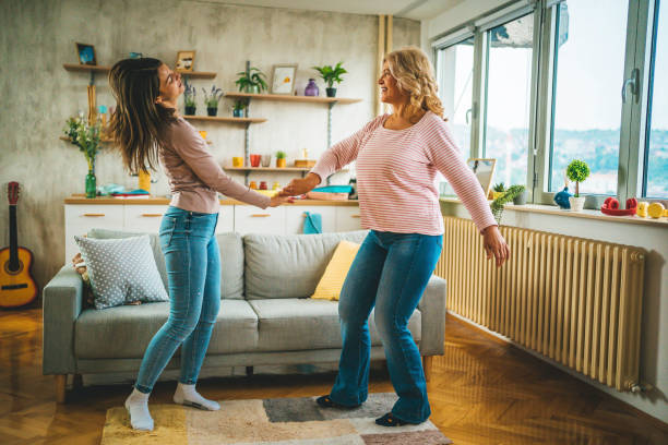 istock Mother and daughter dancing at home 1347929362