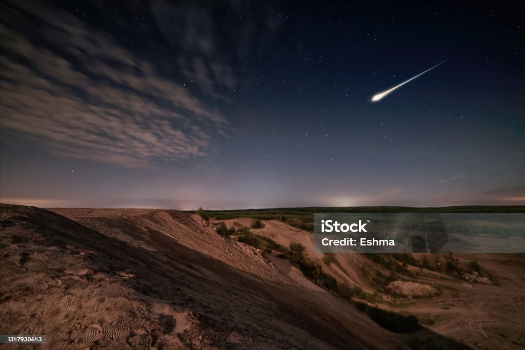 Meteor over sand hills and forest in moon light and starry sky Meteor over sand hills and forest in moon light and starry sky. Long exposure night scene Comet Stock Photo
