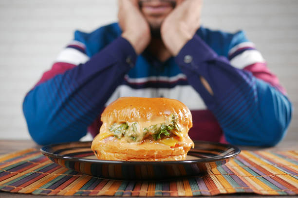 hand holding beef burger on table close up .