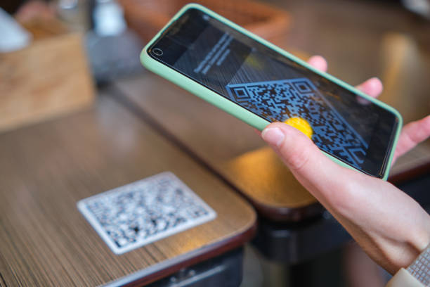 Closeup of guest hand ordering meal in restaurant while scanning qr code with mobile phone for online menu.