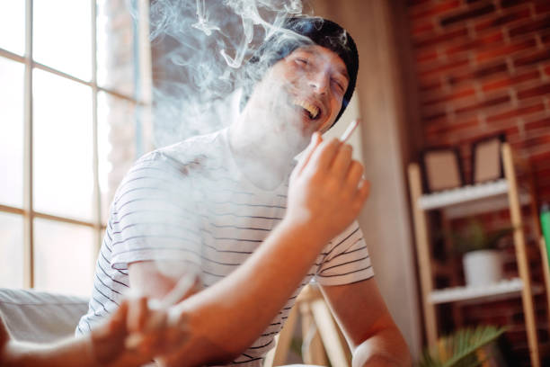 Using marijuana at home Enjoying marijuana in living room substance intoxication stock pictures, royalty-free photos & images