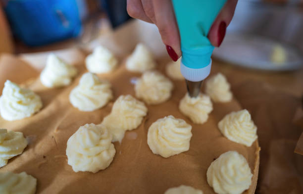 istock Piping Bag Icing Cone used by a female hand to decorate caramel cake 1347935310