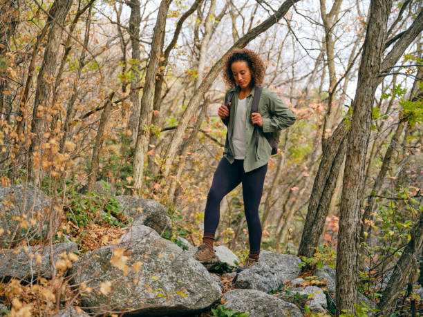 A young woman, hiking alone in an autumn forest.