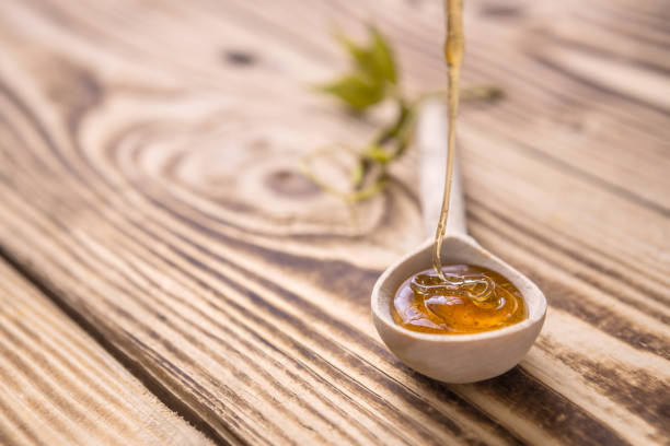 istock fresh honey flows into a wooden spoon lying on a wooden table 1347938238