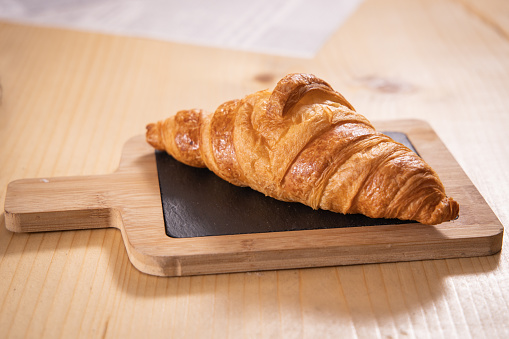 Freshly backed French croissant on wooden board