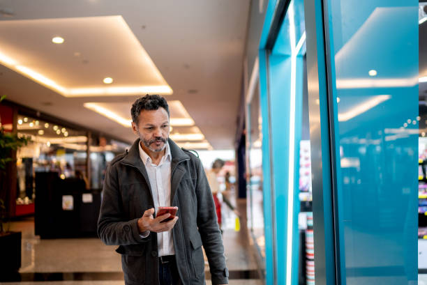 istock Mature man using a smartphone at the mall 1347941816